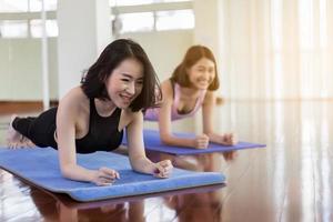 duas mulheres fazendo yoga no ginásio foto