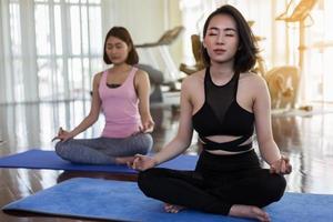 duas mulheres fazendo yoga no ginásio foto