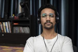 jovem rapaz indiano usando fones de ouvido foto