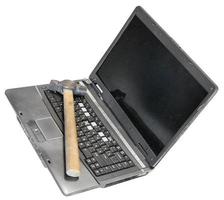 velho laptop defeituoso com martelo no teclado foto