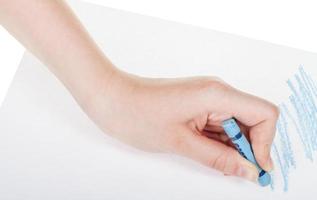 mão desenha por giz de cera azul na folha de papel foto