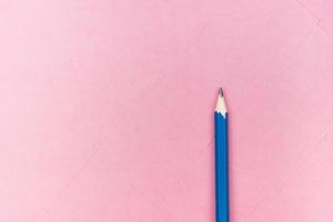 lápis azul sobre fundo rosa foto