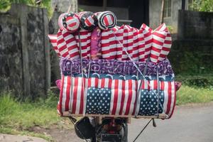 vendedor de matrass de bandeira dos eua de moto em bali indonésia foto