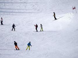 muitos esquiadores esquiando nas montanhas de neve do vale das dolomitas gardena foto