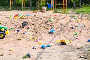 brinquedos esquecidos no playground de areia ao ar livre foto