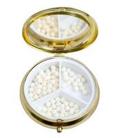 caixa de comprimidos compacta com espelho e bolas de homeopatia foto