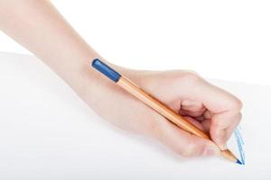 mão escreve por lápis de madeira azul na folha de papel foto