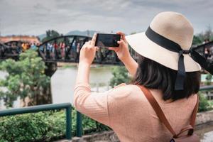 turista tirando uma foto de turismo perto da ponte na Tailândia