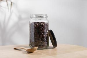 grãos de café torrados escuros em uma jarra de vidro foto