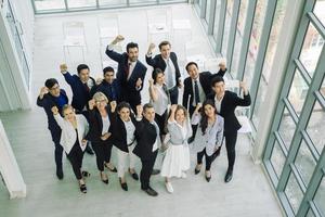 grupo multiétnico de profissionais de negócios com os punhos para cima foto