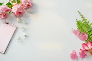 flores cor de rosa com samambaias e smartphone foto