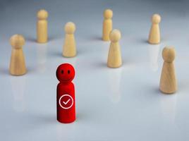 conceito de negócios e rh para liderança e líder de equipe, uma boneca de madeira se destaca na frente diferente e se destaca do grupo foto