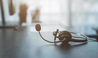 fone de ouvido sentado na mesa no escritório foto