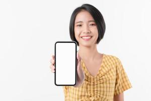 mulher asiática, segurando o smartphone em fundo branco foto