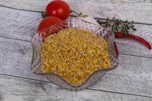 bulgur cru na tigela com tomate e alho foto