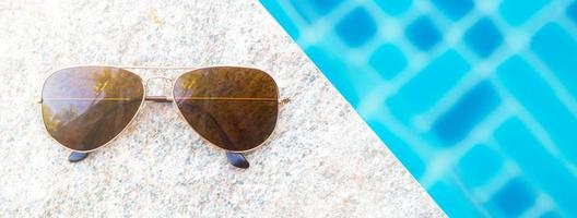 vista superior vista de óculos de sol à beira da piscina