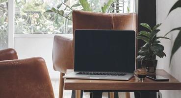 laptop com café expresso e telefone na sala de estar foto