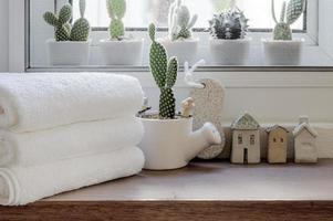 toalhas limpas dobradas com planta de casa no balcão de madeira foto