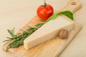 queijo parmesão na tábua de madeira e fundo de madeira foto