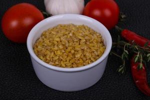 bulgur cru na tigela com tomate e alho foto