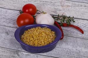 bulgur cru na tigela com tomate e alho foto