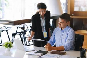 o gerente de marketing masculino expressou sua satisfação em vender os produtos da empresa. onde os membros da equipe mostram as vendas na tela do ipad. foto