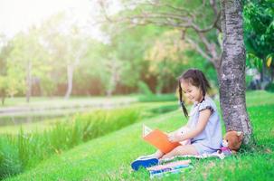 livro de leitura jovem menina asiática em um parque foto