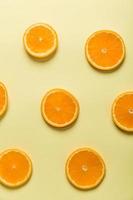 fatias de laranja em fundo amarelo foto