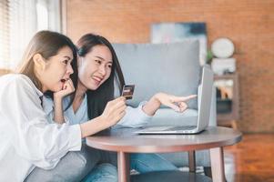 mulheres asiáticas usando cartão de crédito para compras online foto