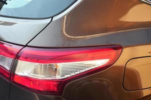 luz traseira vermelha de um close-up marrom do carro de passageiros. foto detalhada de uma das peças do carro
