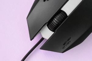 closeup de um mouse óptico de jogos preto em um fundo rosa foto