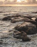 formação rochosa marrom na água do mar foto