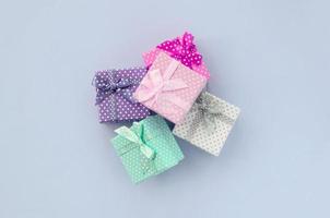 pilha de pequenas caixas de presente coloridas com fitas encontra-se em um fundo violeta foto