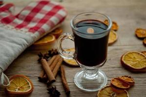 fatias de laranja secas e vinho quente na mesa foto