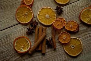 fatias de laranja secas e vinho quente na mesa foto