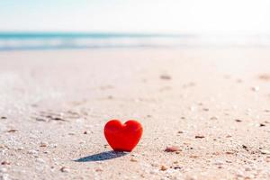 símbolo romântico de coração vermelho na praia de areia foto