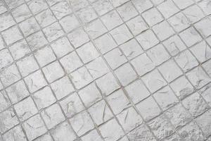 fundo de pavimento de paralelepípedos de granito. textura do pavimento de pedra. abstrato de pavimento de paralelepípedos. superfície texturizada áspera de grandes lajes de pavimentação cinza foto