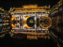 vista da paisagem da ponte de hong e construção na noite da cidade velha de fenghuang. cidade antiga de phoenix ou condado de fenghuang é um condado da província de hunan, china foto