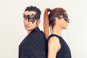 casal usando máscaras pretas em pé de costas. foto