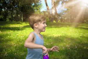 menino feliz durante o dia de primavera no parque. foto