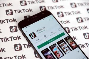 ternopil, ucrânia - 2 de maio de 2022 aplicativo para smartphone tik tok na tela e muitos logotipos tiktok impressos em papel. tiktok ou douyin é um famoso serviço chinês de hospedagem de vídeos curtos de propriedade da bytedance foto