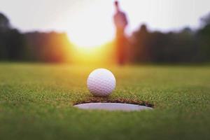 uma pessoa atrás de uma bola de golfe em um campo de grama verde foto
