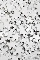 close-up de uma pilha de elementos incompletos de um quebra-cabeça branco. um grande número de peças retangulares de um grande mosaico branco foto