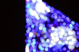 fragmento borrado da árvore do ano novo. muitas luzes redondas em azul foto