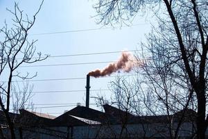 fumaça da chaminé de uma fábrica de produtos químicos contra o céu azul. o problema da poluição ambiental. conceito de ecologia foto