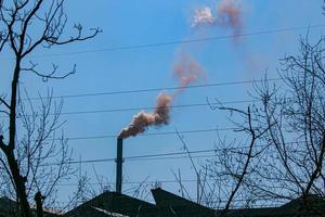 fumaça da chaminé de uma fábrica de produtos químicos contra o céu azul. o problema da poluição ambiental. conceito de ecologia foto