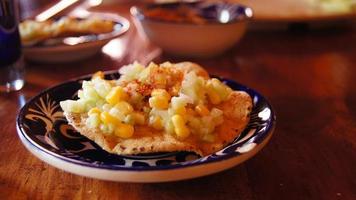 comida mexicana local, tostada de milho com pepino, em prato de cerâmica artesanal com pó picante foto