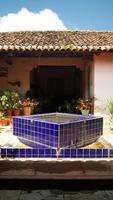 fonte de pedra, na antiga casa mexicana, américa latina, com azulejos decorados, telhas, vegetação circundante foto