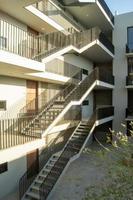 prédio de apartamentos de escadas, portas de madeira de renda de prédio branco, pátio central, méxico foto