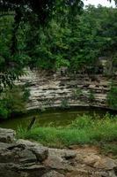 cenote, méxico. lindo cenote na península de Yucatán com águas transparentes e raízes penduradas. chichen itza, américa central. foto